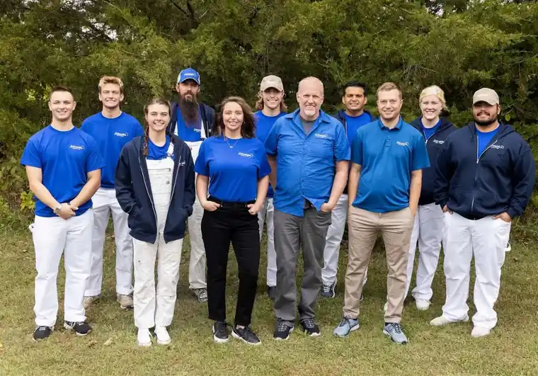 The whole Schneider Painting company, office staff included, with Mike Schneider in a light-blue shirt at the center