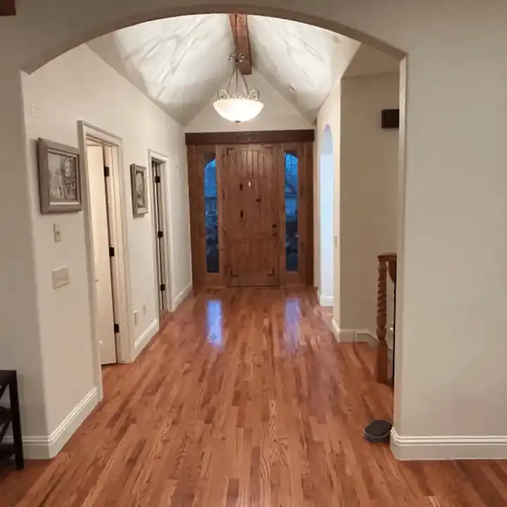 Hallway with a vaulted ceiling and a wood front door