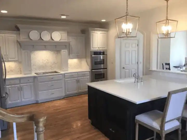 Painted white kitchen cabinets around a dark island