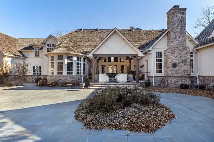 The Sonora project from the rear: stucco gables, stone chimney and a covered patio